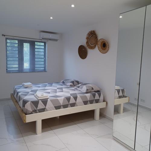 a bedroom with a bed in a white room at Flamingo Apartment - Regal Rentals Curacao in Willemstad