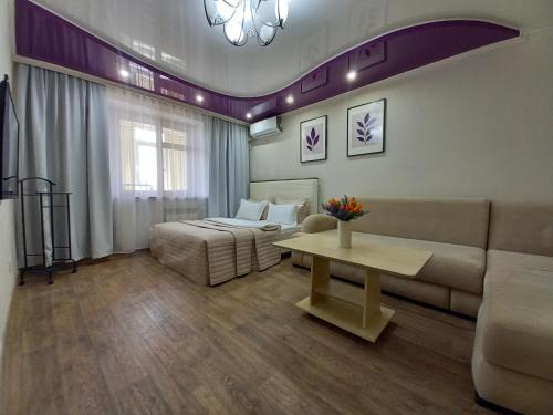 a living room with a couch and a bed and a table at Лунная Гавань in Aktobe