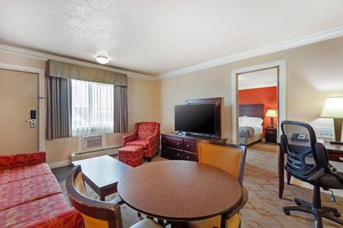 a living room with a couch and a table and a room at Best Western PLUS Mirage Hotel and Resort in High Level