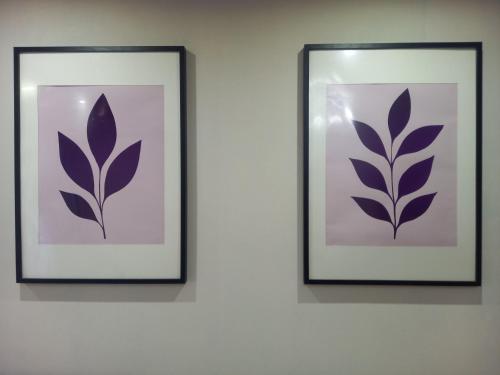 two framed pictures of a plant on a wall at Лунная Гавань in Aktobe