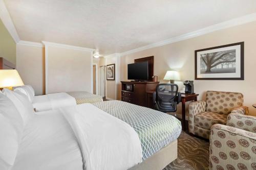 a hotel room with a bed and a chair at Best Western PLUS Mirage Hotel and Resort in High Level