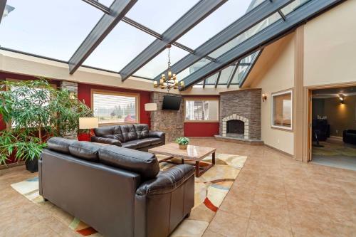 a living room with leather furniture and a fireplace at Best Western PLUS Mirage Hotel and Resort in High Level