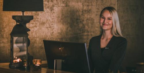 a woman sitting at a desk with a laptop at Lapland Hotels Bulevardi in Helsinki