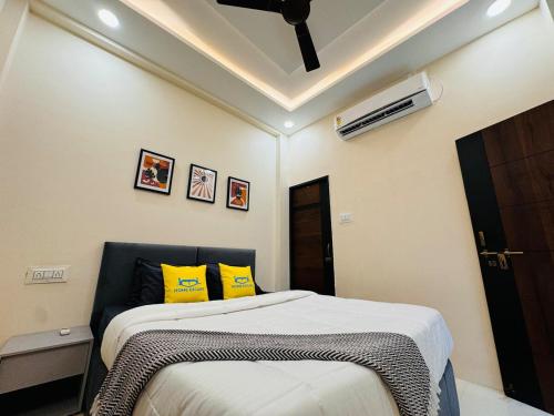 a bedroom with a bed with yellow pillows at Home Escape 2BHK Retreat Pvt Home in Ujjain