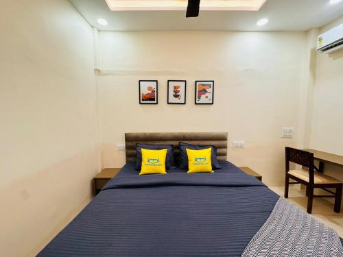a bedroom with a bed with two yellow pillows at Home Escape 2BHK Retreat Pvt Home in Ujjain