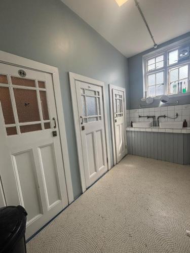 a bathroom with two white doors and a sink at Green Rooms in London