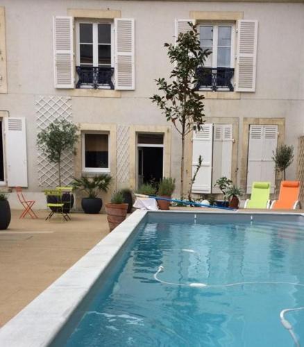 une grande piscine devant un immeuble dans l'établissement Maison indépendante en centre ville, au Mans