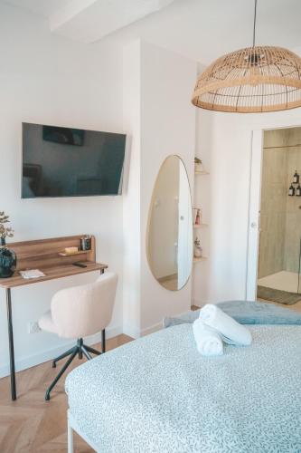 - une chambre avec une table, une chaise et un miroir dans l'établissement Le nid enchanté, à Perpignan