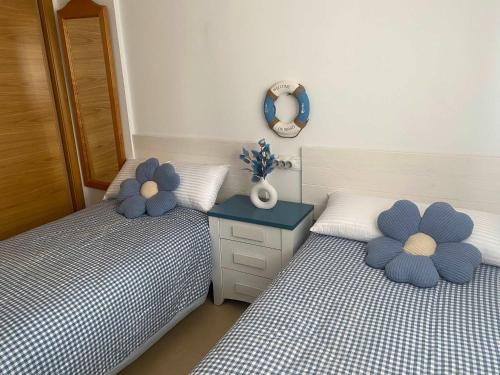 two beds in a bedroom with blue and white at Condado de Alhama Jardin 11 SV51 in Alhama de Murcia