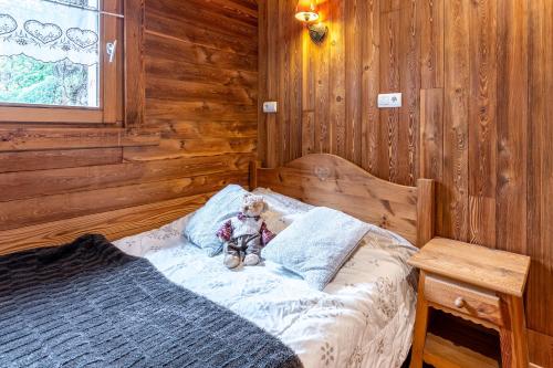 un ours en peluche assis sur un lit dans une cabine dans l'établissement La Poya, à Valloire