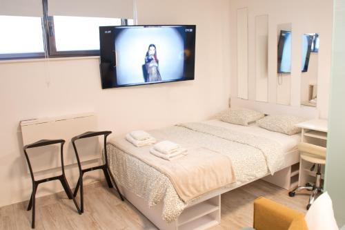 a room with a bed and a tv on the wall at Cozy Condo in Tresnjevka in Zagreb