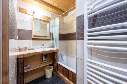 une salle de bain avec un lavabo et un miroir dans l'établissement La Poya, à Valloire