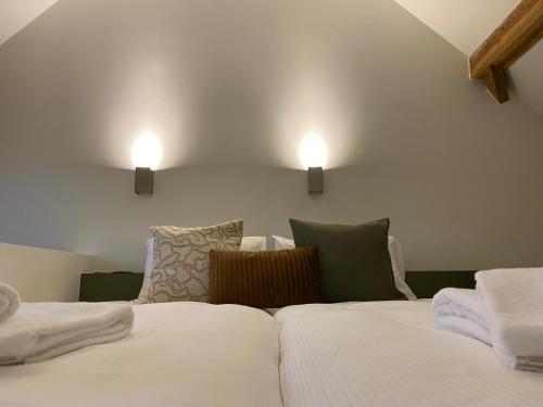 a bedroom with a bed with two lights on the wall at Landgoed De Hoogmolen in Oudsbergen 