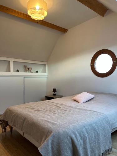 - une chambre avec un lit doté d'un oreiller rose dans l'établissement Maison au haras, à Hotot-en-Auge