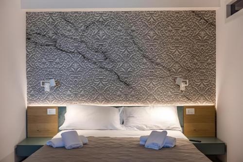 ein Bett mit zwei blauen Kissen darauf in der Unterkunft Luxury terrazza in Bari