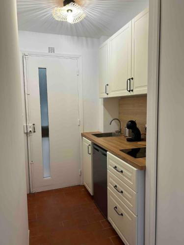 une cuisine avec des armoires blanches et un comptoir dans l'établissement Appartement Saint-Raphael, à Saint-Raphaël