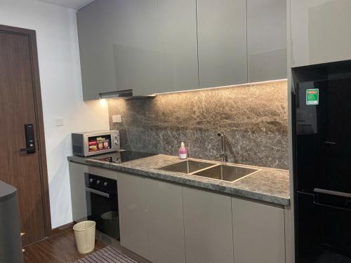 a kitchen with a sink and a microwave at Lustay StudioH3 Hawaii Masteri- Luxury Furnished in Gia Lâm Pho