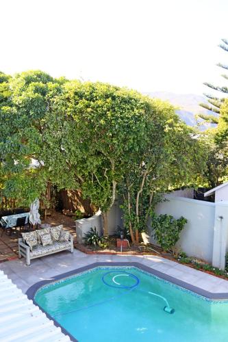 a small swimming pool in a yard with a tree at Wholeness Accommodation in Hermanus