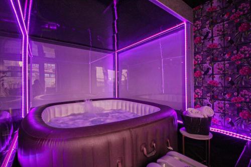 bañera de hidromasaje con iluminación púrpura en una habitación en 1 Bed Penthouse - Hot Tub - Roof Terrace - Parking, en Birmingham