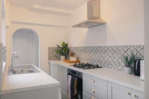 a white kitchen with a sink and a stove at Modern 3 Bedroom Home in Central Rugby in Rugby