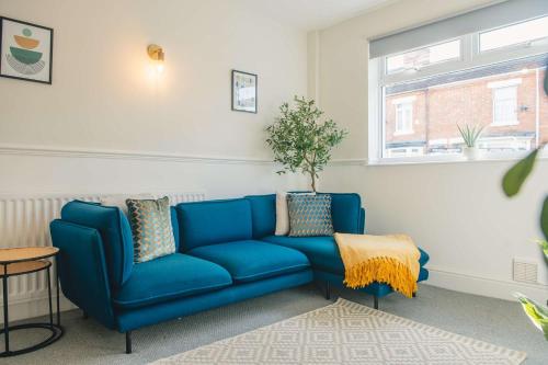 a blue couch in a living room with a window at Modern 3 Bedroom Home in Central Rugby in Rugby
