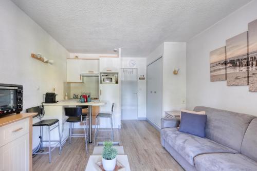 un salon avec un canapé et une cuisine dans l'établissement Les Cigales de la Mer - 7min à pied du Port, à Saint-Cyr-sur-Mer
