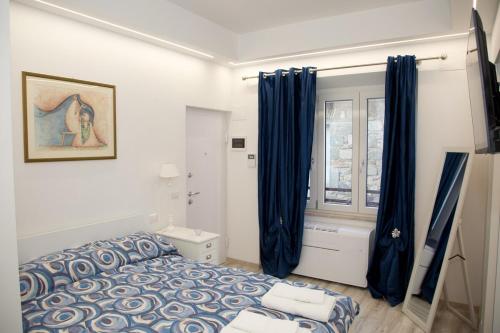 a bedroom with blue curtains and a bed and a window at Sweet Home in San Rocco in Bolsena