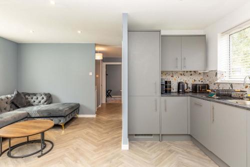 a kitchen and a living room with a couch and a table at Modern & Stylish 3 Bedroom Home in Peterborough in Peterborough
