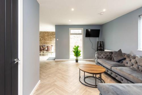 a living room with a couch and a table at Modern & Stylish 3 Bedroom Home in Peterborough in Peterborough