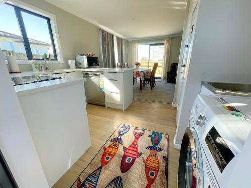 a kitchen with white counters and a kitchen rug on the floor at Brand new, close to hospital, plenty of parking sapces in Hamilton