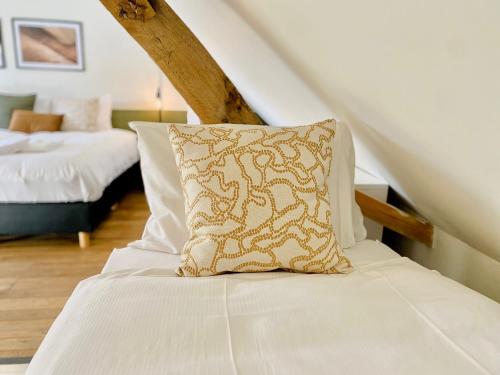 a bed with a pillow on it in a room at Landgoed De Hoogmolen in Oudsbergen 