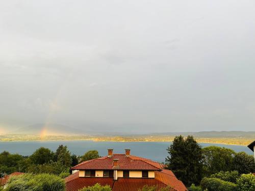 a house with a rainbow in the background at Villa Vista Lago in Massino Visconti
