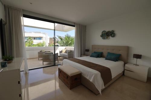 a bedroom with a large bed and a balcony at Serenity by the Sea in La Valvega, La Cala de Mijas in La Cala de Mijas