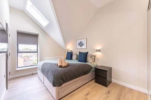a bedroom with a large bed with blue pillows at Maple Apartments - Modern 2 Bed Apartment in Derby in Derby