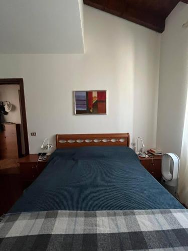 a bedroom with a bed with a blue comforter at Villa Vista Lago in Massino Visconti