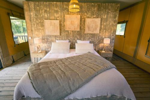 a bedroom with a large bed with two lamps at You and Me Glamping in Moncontour-de-Poitou