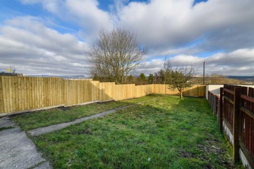 a wooden fence in a yard with a grass yard at 3 Bedroom Spacious and Homely Welsh Retreat in Coelbren