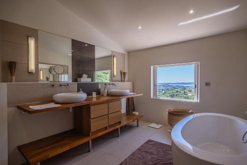 a bathroom with a tub and a sink and a bath tub at Azuréenne de la Nartelle in Sainte-Maxime