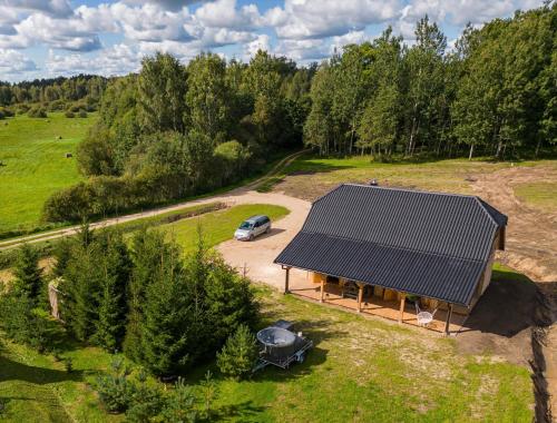 an overhead view of a house with a car parked in a field at Nomadic Homes holiday home with sauna in Ķevele