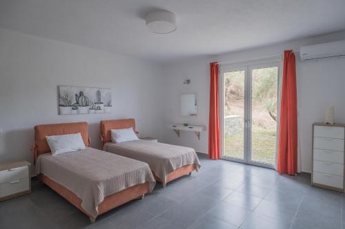 a bedroom with two beds and a window at Aegean Breeze Skiathos in Skiathos Town
