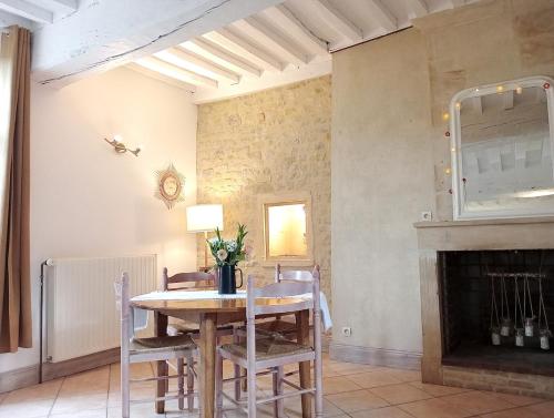 une salle à manger avec une table et une cheminée dans l'établissement La maison perchée, à Bayeux