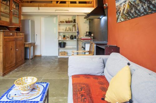 un salon avec un canapé et une cuisine dans l'établissement Appartement bord de Nive Bayonne, à Bayonne