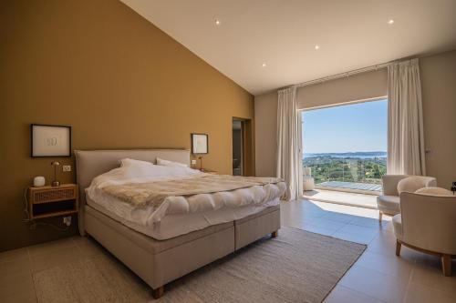 a bedroom with a large bed and a large window at Azuréenne de la Nartelle in Sainte-Maxime