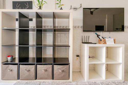 a room with white shelves and a tv at Silver Coast by Seareen in Armação de Pêra