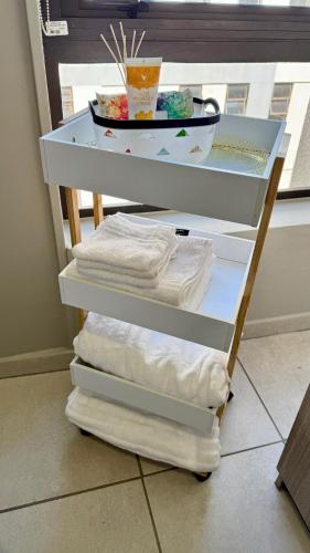 a shelf with towels and a bowl on top of it at The Bolton Rosebank in Johannesburg