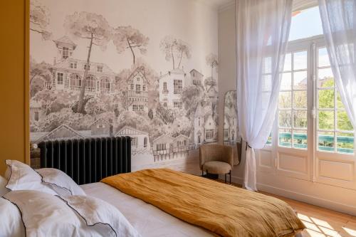 une chambre avec une fresque de maisons sur le mur dans l'établissement Appartement vue mer plein centre Arcachon, à Arcachon