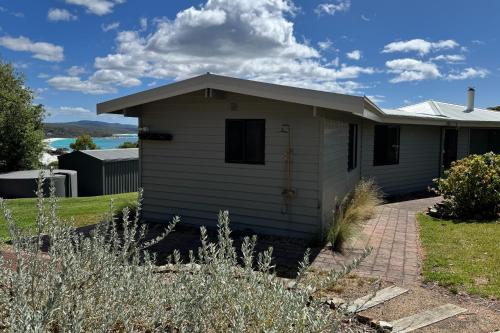 a small white house with a driveway at HEXAGON BEACH HOUSE Binalong Bay of Fires Views in Binalong Bay