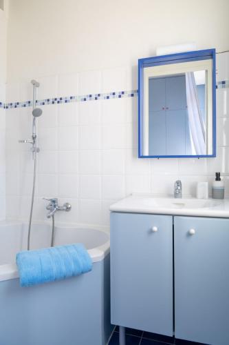 une salle de bain avec un lavabo, un miroir et une baignoire dans l'établissement Appartement vue mer plein centre Arcachon, à Arcachon