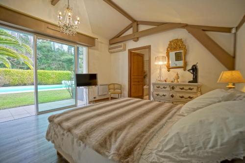 une chambre avec un lit, une télévision et une fenêtre dans l'établissement Très belle villa avec piscine, à Biarritz