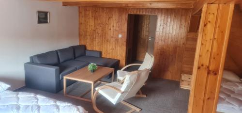 a living room with a couch and a table at Penzion V Kopci in Kořenov